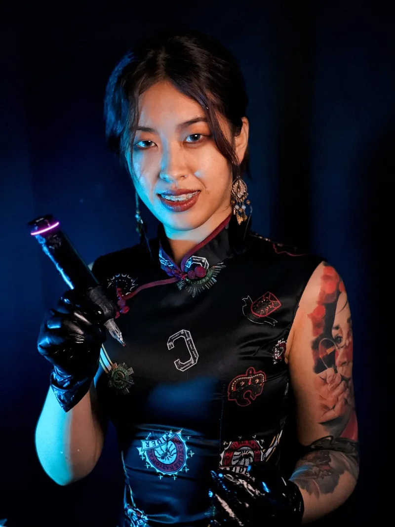Cathy Xiaonie demonstrating tattoo technique - Chongqing realism artist holding professional tattoo machine